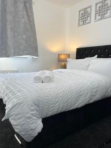 a bedroom with a bed with two towels on it at Home In Maidstone in Maidstone