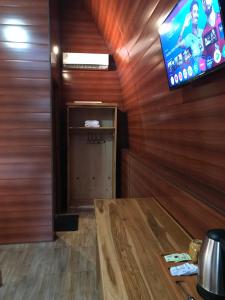 a room with a tv and a wooden wall at Bale Rinjani Bungalows in Tetebatu +14 photos