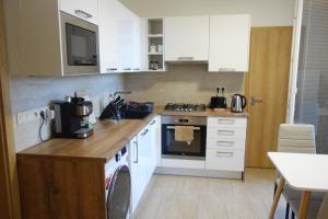 a kitchen with white cabinets and a stove top oven at Apartmán Sofia in Levice