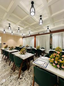 バンガロールにあるROYAL ACE BOUTIQUE HOTEL - Bhartiya Cityのダイニングルーム(テーブル、緑の椅子付)