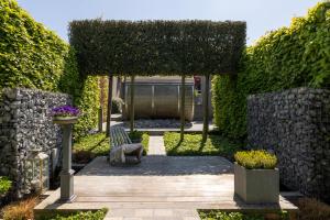 a garden with a bench and ivy at Vakantiewoning Relax Ohm in Zottegem