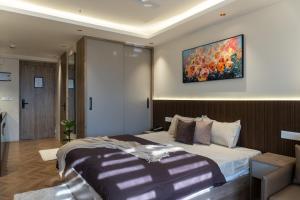 a bedroom with a bed and a painting on the wall at Stylish & Comfortable Studio near Expo Center Greater Noida opposite Metro in Greater Noida