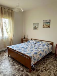 a bedroom with a bed with a blue comforter at Domus Maris in Marina di Ascea