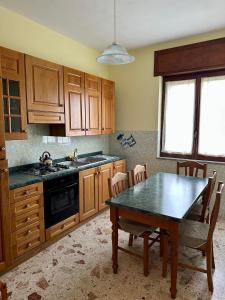 a kitchen with wooden cabinets and a table with chairs at Domus Maris in Marina di Ascea