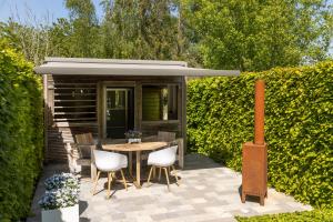 a patio with a table and chairs and a building at Vakantiewoning Relax Ohm in Zottegem