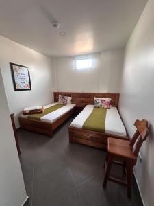 a room with two beds and a chair in it at Parque Orquídeas Hotel in Urrao