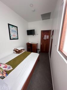 a bedroom with a bed and a television in it at Parque Orquídeas Hotel in Urrao