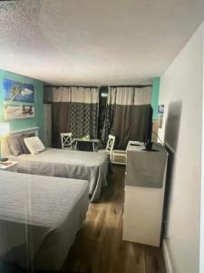 デイトナビーチにあるOceanside apartment with Seaview 803のベッド2台とテーブルと椅子のある寝室