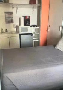 デイトナビーチにあるOceanside apartment with Seaview 803のベッド1台付きの部屋、電子レンジ付きのキッチン +5枚の写真