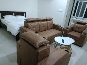 a bedroom with couches and a bed and a table at RVR TOWN LODGe 