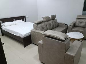 a bedroom with a bed and a couch and a chair at RVR TOWN LODGe 