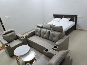 a bedroom with a couch and a bed and a chair at RVR TOWN LODGe 