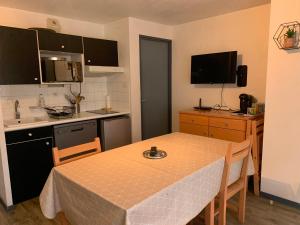eine Küche mit einem Tisch und eine Küche mit einem Tisch und Stühlen in der Unterkunft Appart T2 Cabine Village Saint Lary Soulan in La Celle-sous-Gouzon