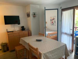 ein Esszimmer mit einem Tisch und ein Schlafzimmer in der Unterkunft Appart T2 Cabine Village Saint Lary Soulan in La Celle-sous-Gouzon