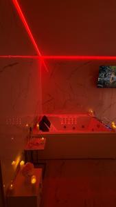 a red lighted bathroom with a tub and a table at Jacuzzi Bliss by the Motława in Gdańsk +28 photos