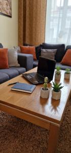 a coffee table with a laptop on top of it at City Center Apartament in Ternopilʼ