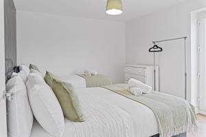 ein weißes Schlafzimmer mit zwei Betten mit Kissen in der Unterkunft 2 Bed Apartment Near City Centre - on street parking in Birmingham + 1 Foto