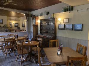 a restaurant with wooden tables and chairs and a bar at The Bridge Inn in Reeth