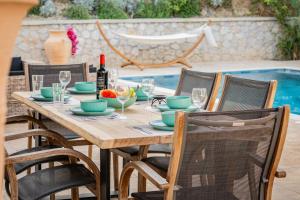 a wooden table with chairs and a bottle of wine at Villa Splendide in Rhodes Town