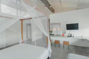 a bedroom with a bed and a kitchen with chairs at Super Villa In Unawatuna Sunny beach in Kadawatha