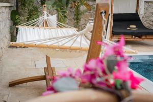 a white hammock sitting next to a table with flowers at Villa Splendide in Rhodes Town +36 photos