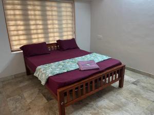 a small bed in a room with a window at Dragster Homes Alwaye in Alwaye