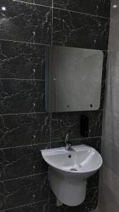 Un baño con un lavabo y un espejo en la pared. en Calm Studio, en Yeda