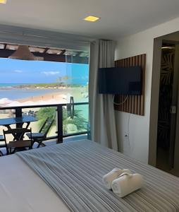 a bedroom with a bed with a view of the beach at MAR DÁ LIBERDADE com Villa das Ondas in Morro de São Paulo