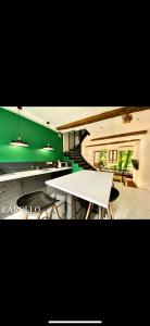a kitchen with a white table and a green wall at Ô Berge De La Cité in Carcassonne