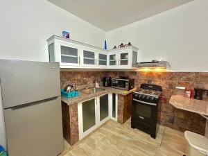 a kitchen with a refrigerator and a sink at Mi Refugio 1 in Río San Juan