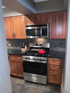 a kitchen with a stove and a microwave at Ski-In, Ski-Out Sunrise Village Killington Condo - 2BR, Fireplace, Pool, Pet Friendly in South Sherburne
