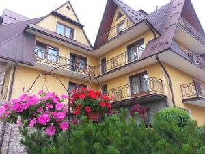 un bâtiment avec des fleurs devant lui dans l'établissement U Hani w pobliżu Gorący Potok i Termy, à Szaflary