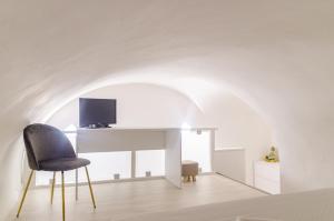 a room with a chair and a desk with a television at San Pio - Cozy Apt Near Bari Central Station in Bari
