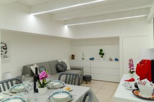 a living room with a table and a couch at San Pio - Cozy Apt Near Bari Central Station in Bari +21 photos