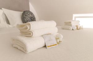 a pile of towels sitting on top of a bed at San Pio - Cozy Apt Near Bari Central Station in Bari