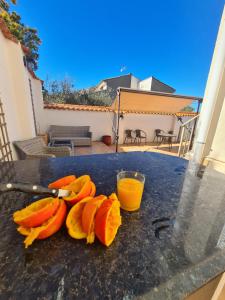 a pile of sliced fruit on a table with a glass of orange juice at Quesa Tranquil Valencia in Quesa