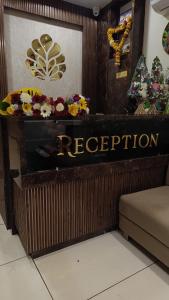 a reception sign in a room with flowers on it at Shri ShyamRaj Hotel Ujjain in Ujjain