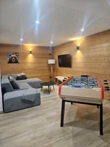 Una sala de estar con una cama y una mesa de billar. en Chalet Louline - Châtel, en Châtel