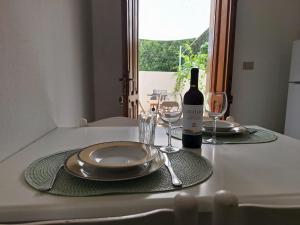 a table with two plates and a bottle of wine at Martina Domus,South Sardinia, 5-star sea in Carbonia