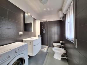 a bathroom with a washing machine and a toilet at Martina Domus,South Sardinia, 5-star sea in Carbonia