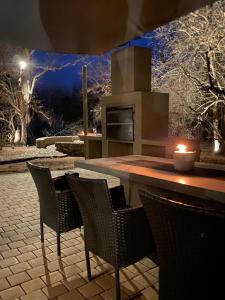 eine Terrasse mit einem Tisch, Stühlen und einem Herd in der Unterkunft Luvivane Luxury Villa in Marloth Park