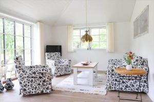 ein Wohnzimmer mit Stühlen und einem Tisch und Fenstern in der Unterkunft 11126-1 Nykøbing Sj - Slåenhækken 18 in Nykøbing Sjælland