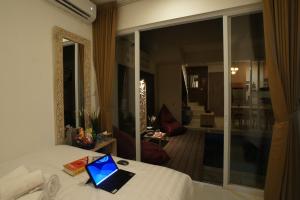 un ordenador portátil sentado en una cama en una habitación en Azura Villas Nusa Dua, en Ungasan