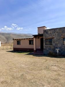 a house in the desert with mountains in the background at Los Leños in Tafí del Valle