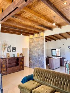 a living room with a couch and a stone wall at Los Leños in Tafí del Valle