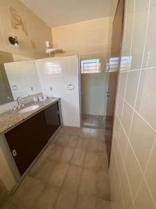 a bathroom with a sink and a shower at Casa em Guaratinguetá-Casa da Rosa in Guaratinguetá