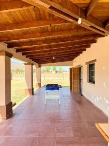 a large patio with a wooden ceiling and a table at Los Leños in Tafí del Valle