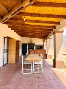 a patio with a table and chairs under a wooden ceiling at Los Leños in Tafí del Valle