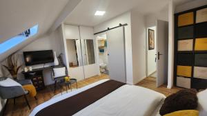 une chambre avec un lit et une télévision dans une pièce dans l'établissement La belle chambre au fil de l'eau, à Douai