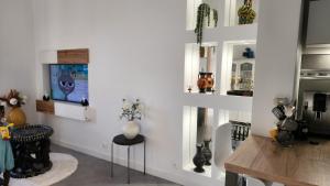 un salon avec une télévision et une table dans l'établissement La belle chambre au fil de l'eau, à Douai